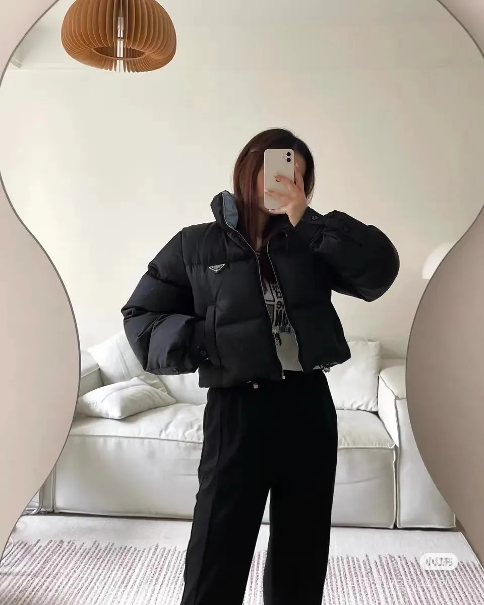 Prada普拉達24ss尼龍三角標短款高腰女款羽絨服 鵝絨'22短款羽絨服專櫃同步新款立領五金logo拉鍊設計~彈力抽繩下擺蓬鬆有型~ 鵝絨填充巨保暖內里黑撞蘭細節質感在線款 定制的尼龍面料 完全一致的手感進口膽布不怕鑽絨 短款裁剪非常酷√細節完美首單現 貨號927600003 尺碼:36-42 編碼:TES101606