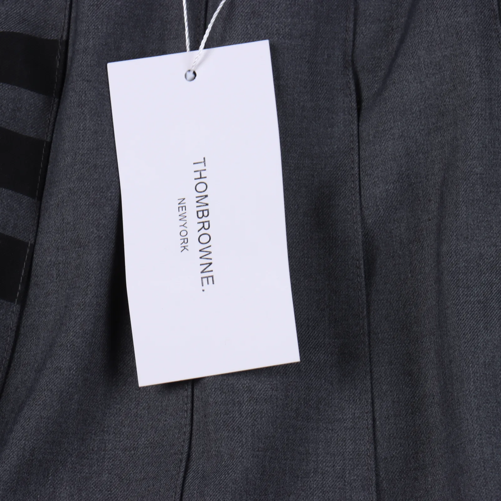 THOM BROWNE .湯姆布朗 TB四條槓前短後長開叉經典短裙                   圓形紅白藍拉鍊頭   面料採用高檔免燙西裝面料  里布面料採用官網正品條紋面料   內裡搭配安全褲防走光  外側隱形拉鍊  腰圍採用高檔貝殼扣  收腰鈕扣  三標齊                  標配正品字母防塵袋                做工採用進口縫紉設備縫製 針距細密  料子不縮水不褪色                 顏色：灰色                尺碼：0/1/2                編碼：NHE050702