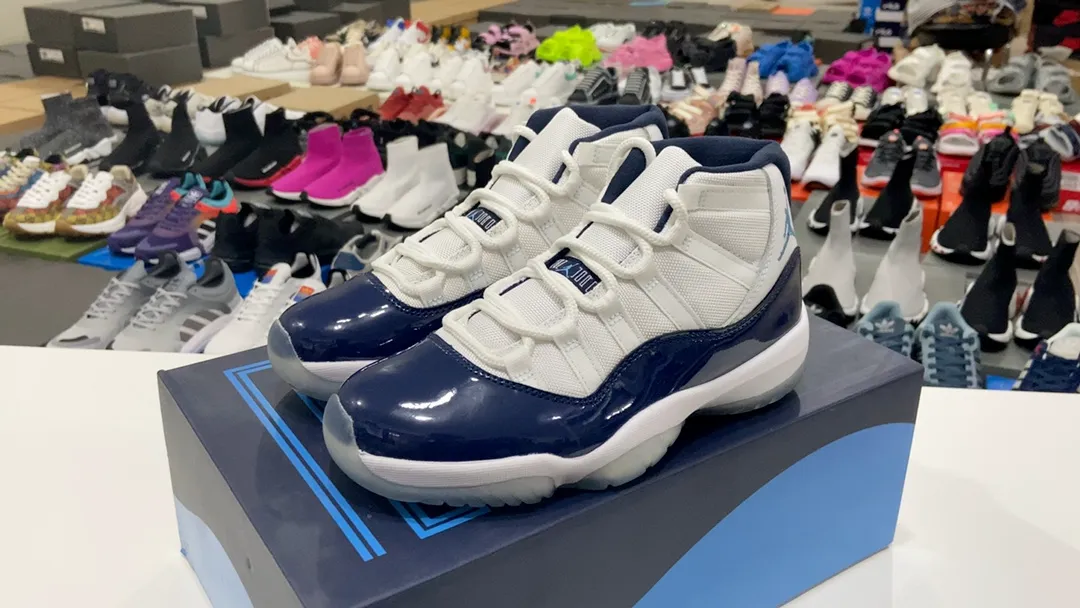 高版本真碳喬丹Air Jordan 11 “Win Like 82”北卡配色鞋款採用與 Air Jordan 11 “Concord” 相似的配色方案,海軍藍漆皮搭配白色尼龍鞋身,後跟點綴北卡色 Jumpman Logo,鞋盒依然以經典的高規格抽屜式呈現,給人一種熟悉又新鮮的視覺感受!