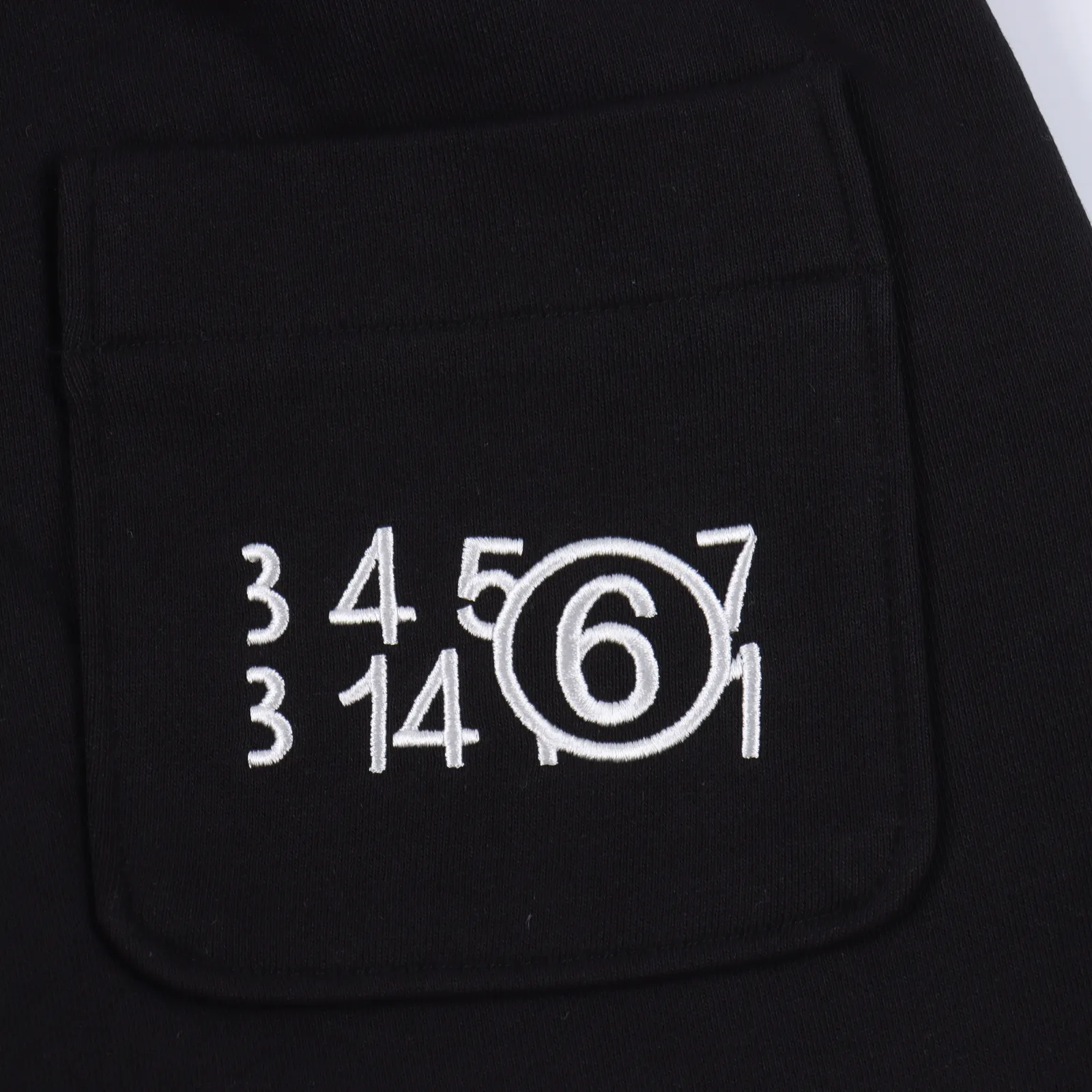 Maison Margiela 馬吉拉 四針縫線刺繡logo運動短褲                 寬鬆式的直筒剪裁 休閒與運動都能駕馭 無性別定義 腰部帶有彈力並附有外部抽繩 兩側弧形開口的直叉口袋 在左側大腿上有“去標籤化”理念的特色標籤刺繡 便是放大了的四角縫線logo 後背有一個尾袋上面是經典又熟悉的數字刺繡 圓圈內放大的數字“6”便是該款褲子的系列所在 尾標處依然有四角針線 400克全棉毛圈 正品級                SIZE:S-XL                編碼：EIO062451