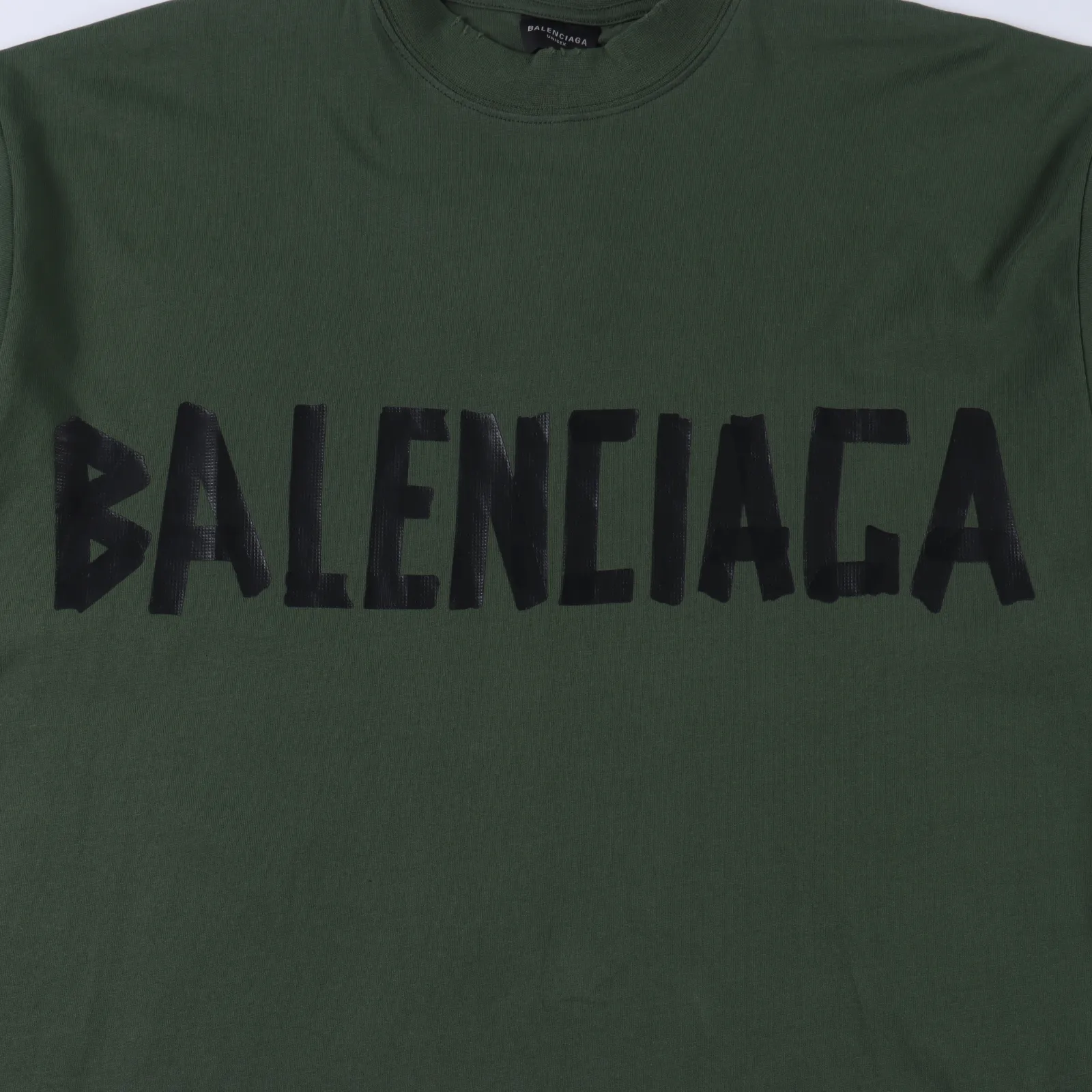 Balenciaga巴黎世家 膠帶短袖                原版衣服都是做過噴馬騮工藝 買現成布顏色會不均勻 出現一條一條很明顯的痕跡 印花細節比較多需要一點點摳 從打色到上膚面漿再烘乾半小時一次 足足13次調色可以說是調色天花板了耗費5個小時 每一件都需要人工點位破洞 按原版破洞 不隨意破洞 ，權威版本，隨意對比市面任何品質。                